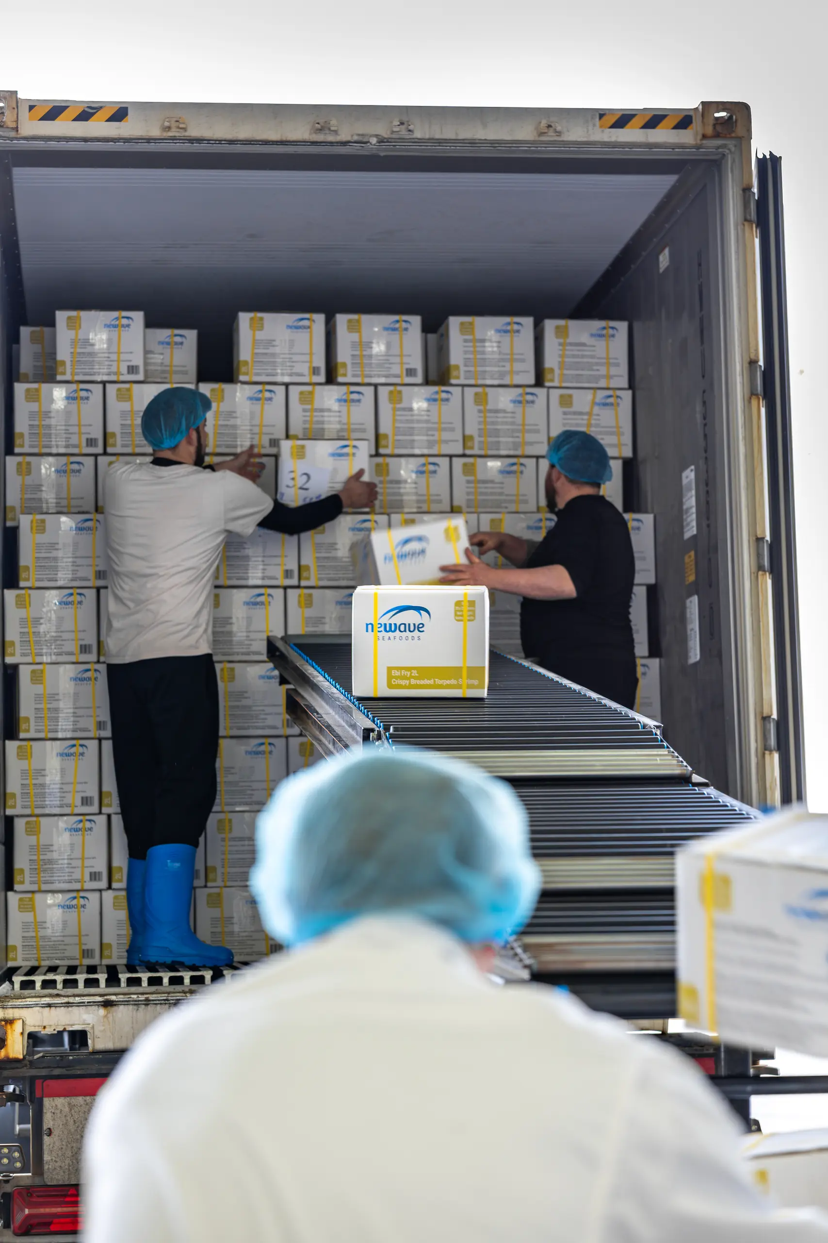 het uitladen van een container garnalenproducten door Fix Fisch